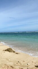 Soft blue sea waves on a clean sandy beach