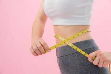 Diet and dieting. Beauty slim female body use tape measure. Woman in exercise clothes achieves...