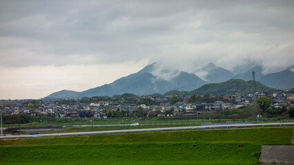 Fototapeta premium 雨上がりの皿倉山と帆柱山を覆う雲を遠賀川側から見る