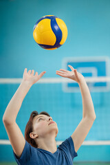 Young girl learning fundamental skills to play volleyball. Photo in action of a girl training to...
