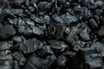 Dark coal texture, the remnants of wood burning into charcoal that can be used for barbecue. selective focus and soft focus