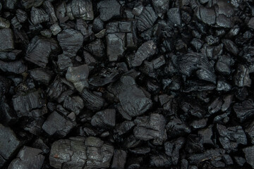 Dark coal texture, the remnants of wood burning into charcoal that can be used for barbecue. selective focus and soft focus
