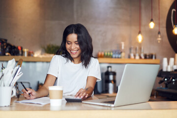 Successful small business owner calculating cafe income in coffee shop