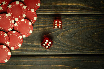 Poker dice with a winning combination on a black vintage table and chips from a lucky bet. Free...