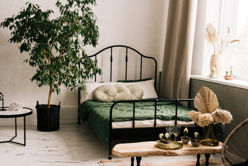 Stylish decor with a black wrought-iron bed and beautiful decor details, geocints, vases, flowers...