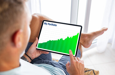 Man looking at investment portfolio growth chart on tablet computer