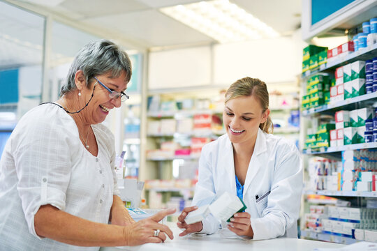 Pharmacist explaining prescription medication to woman in the pharmacy for pharmaceutical healthcare treatment. Medical, counter and female chemist talking to patient on medicine in clinic dispensary