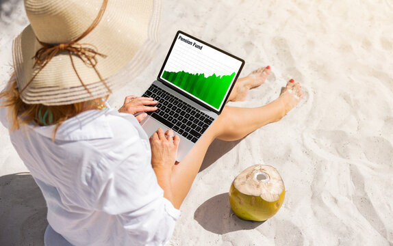 Woman sitting on a beach and looking at pension fund growth chart on laptop computer