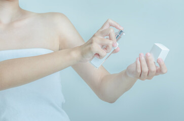 Asian female hand holding a white bottle in her hand.