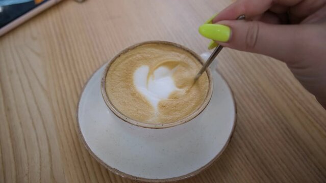 A cup of cappuccino on a table in a cafe. Coffee milk drink in a public place. Milk foam heart