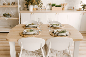 Kitchen white wooden kitchen with Scandinavian-style dining area decorated with mimosa