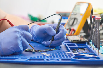mobile phone repair. Measuring the current in a electrical circuit of smartphone with multimeter