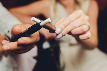 heat-not-burn tobacco product technology. Two woman e-cigarette in his hand before smoking.