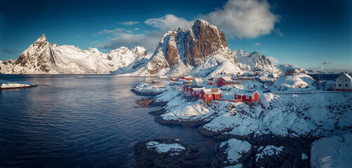 Hamnoy fishing village on Lofoten Islands, Norway with red rorbu houses in winter. Concept of Travel and holiday on nature, tourist and fishing leisure. Iconic location for landscape photographers - obrazy, fototapety, plakaty