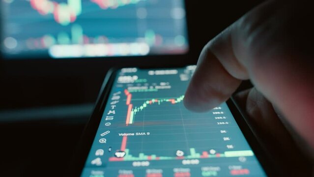 Trader investor holding mobile phone analyzing financial crypto stock market