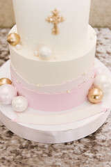 A big beautiful pink and white cake for a baby for baptism