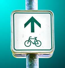 Information sign with a green arrow and the pictogram of a bicycle to indicate the course of a...