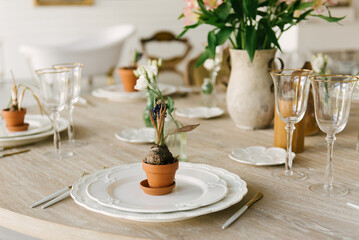 Dining table with beautiful setting, glasses and fresh flowers