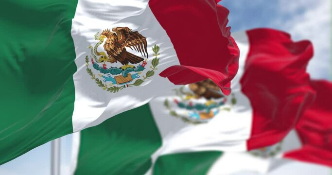 Seamless loop in slow motion of Three Mexican national flags waving in the wind