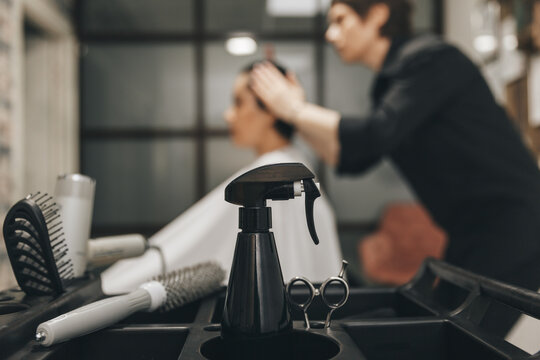Professional barber set on a blurred background with a hairdresser doing a haircut to a client