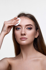 Fototapeta premium woman holding white cotton pad for removing makeup