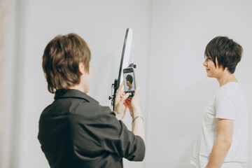 The hairdresser photographs his client in a new way. the hairdresser photographs the result for his portfolio