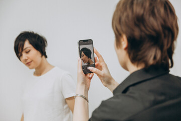 The hairdresser photographs his client in a new way. the hairdresser photographs the result for his portfolio