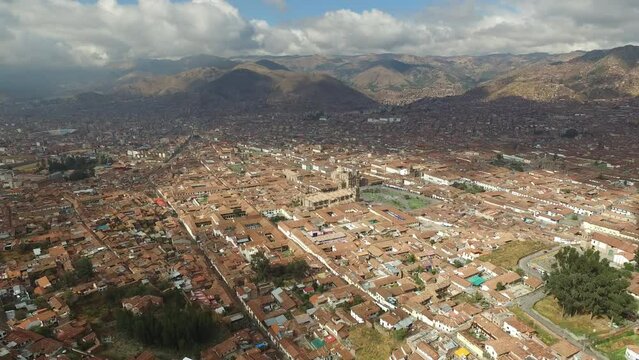 Aerial - Forward tilt up on historical city of cusco, peru. Sky high drone shot