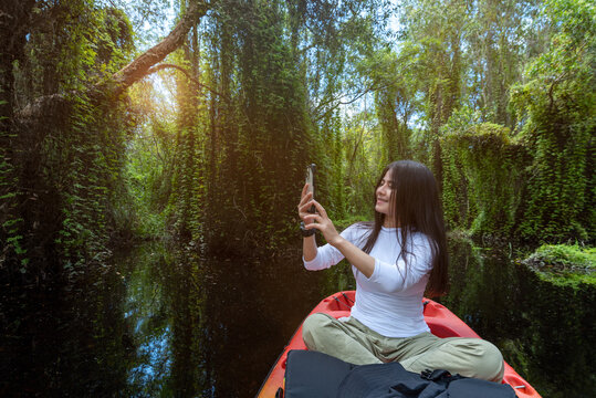 Tourists kayak and canoe taking nature photos in Thailand's flooded fields ,selfie