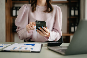 Business woman sitting front tablet ,laptop computer with financial graphs and statistics on monitor.at modern office