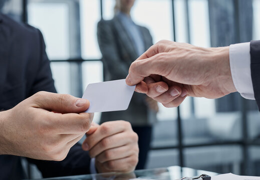 Close up of male employee stretch hand suggest give white mockup blank empty business card to client