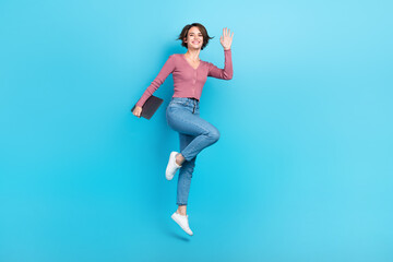 Fototapeta na wymiar Full size photo of gorgeous cheerful girl hand hold netbook jumping isolated on blue color background