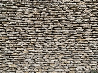 Stone wall made of natural material. Gray bricks are stacked on top of each other. Background texture: masonry concrete wall.