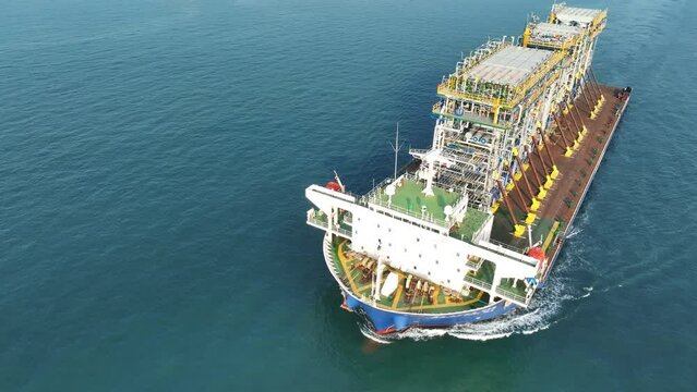 Tender Drilling Oil Rig on Barge Ship transportation Rid to Oil Rig in The Middle of The Ocean at Sunset. Barge Ship transport Big equipment of oil rid.