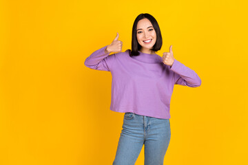 Photo of young optimistic charming japanese girl thumbs up advertising recommendation good deals isolated on yellow color background