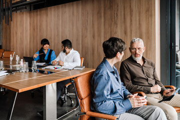 Four colleagues of multinational team discussing projects in office
