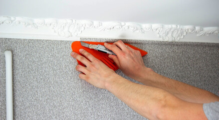 A man glues wallpaper, repairs the house.