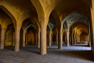 Fototapeten "Vakil" mosque praying hall with spiral pillars of stones and roof tiling illuminated with sunlight located in Shiraz  Iran © Samet