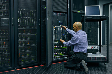 Database, software and a man engineer in a server room for cybersecurity maintenance on storage hardware. Computer network or mainframe with a technician working on information technology equipment - obrazy, fototapety, plakaty