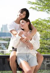 Naklejka premium Romantic young couple in love happy romance relationship together. Portrait of handsome man tenderly embracing his beautiful girlfriend with affection. Lover enjoying valentine, honeymoon or dating.