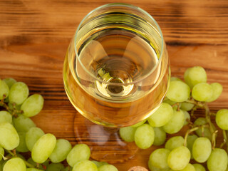 Glass of white wine and grapes on a wooden background. Close-up glass of white wine.