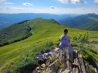 Podróżniczy styl życia. Wędrówka młodej kobiety przez zielone góry Bieszczady.