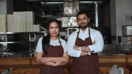 Confident multinational business owners look into camera in cafe