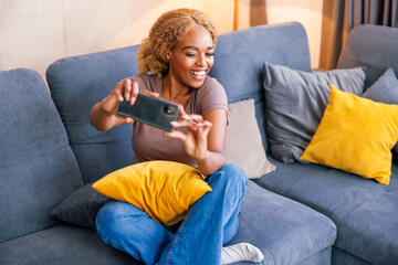 Obraz premium Woman taking selfies while spending leisure time at home