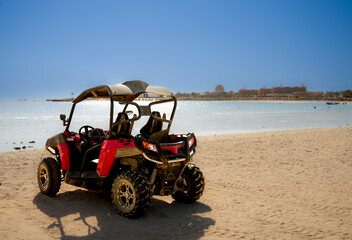 Red empty quad on the beach, seafront, tourist resort, active sport, quad dessert , quad bike, no...