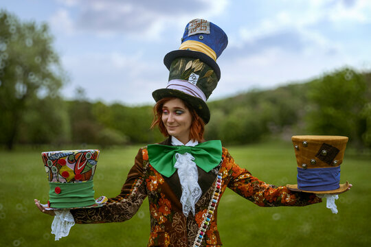 Beautiful woman as mad hatter with hats in nature