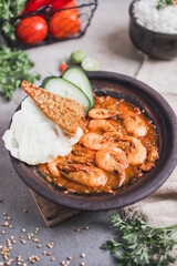 Udang sambal gami or spicy prawn is Traditional food from Indonesia. served on plate with a bowl of rice and vegetables. Isolated gray background
