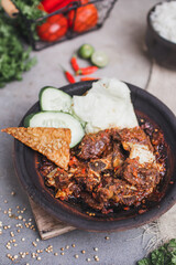 Iga sapi sambal gami or spicy 
beef ribs is Traditional food from Indonesia. served on plate with a bowl of rice and vegetables. Isolated gray background
