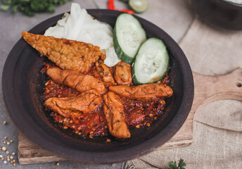 Otak otak sambal gami or spicy fish cake is Traditional food from Indonesia. served on plate with a bowl of rice and vegetables. Isolated gray background and