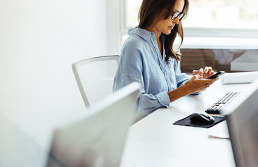 Female business executive using a mobile phone in her office